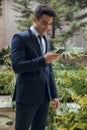 Smiling Young boy with suit and tie using black mobile phone Royalty Free Stock Photo