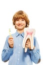 Smiling young boy with tooth model and toothbrush