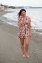 Smiling young brunette caucasian woman chatting on a red mobile phone in the beach. People lifestyle concept Royalty Free Stock Photo