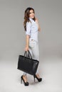 Smiling brunette girl with large handbag Royalty Free Stock Photo