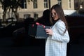 Smiling young brunette woman holding black box. Choosing gift for man. Happy girl with gift Royalty Free Stock Photo