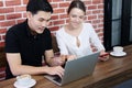 Smiling young business couple loves Asian man and caucasian woman holding credit card for online shopping and paying in social Royalty Free Stock Photo