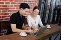 Smiling young business couple loves Asian man and caucasian woman holding credit card for online shopping and paying in social Royalty Free Stock Photo