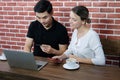 Smiling young business couple loves Asian man and caucasian woman holding credit card for online shopping and paying in social Royalty Free Stock Photo