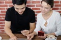 Smiling young business couple loves Asian man and caucasian woman holding credit card for online shopping and paying in social Royalty Free Stock Photo