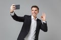 Smiling young business man in classic black suit shirt isolated on grey background. Achievement career wealth business Royalty Free Stock Photo