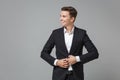 Smiling young business man in classic black suit shirt posing isolated on grey background. Achievement career wealth Royalty Free Stock Photo
