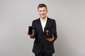 Smiling young business man hold mobile phone with blank empty screen metal bank safe for money accumulation isolated on Royalty Free Stock Photo