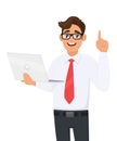 Smiling young business man holding new brand laptop and pointing finger up. Person gesturing idea/solution. Male character design.