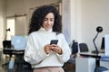 Smiling young business woman manager using phone standing in office. Royalty Free Stock Photo