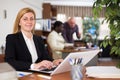 Smiling young business woman sitting at office desk Royalty Free Stock Photo