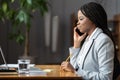 Successful businesswoman or secretary talk on phone call with boss writing notes sit at office desk Royalty Free Stock Photo