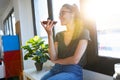 Smiling young business woman using her free hands to make a call with mobile phone in the office Royalty Free Stock Photo