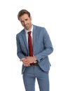 Smiling young businessman in blue suit being happy and rubbing palms Royalty Free Stock Photo