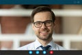 Smiling young businessman in eyeglasses looking at web camera. Royalty Free Stock Photo