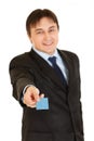 Smiling young businessman giving credit card.