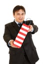 Smiling young businessman giving shopping bag Royalty Free Stock Photo