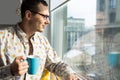 young businessman holding coffee cup in office entrepreneur looking through window while standing in modern workplace Royalty Free Stock Photo