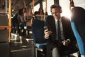 Smiling young businessman listening to music on his morning comm Royalty Free Stock Photo