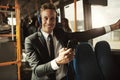 Smiling young businessman standing on a bus listening to music Royalty Free Stock Photo