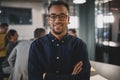 Smiling young businessman standing with his arms crossed at work Royalty Free Stock Photo