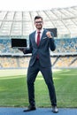 Smiling young businessman in suit showing Royalty Free Stock Photo