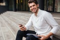 Smiling young businessman using mobile phone outdoors Royalty Free Stock Photo