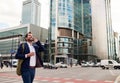 Smiling businessman walking through the city talking on his cellphone Royalty Free Stock Photo