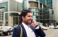 Smiling businessman walking in the city talking on his cellphone Royalty Free Stock Photo