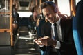 Smiling young businessman listening to music on his morning comm Royalty Free Stock Photo