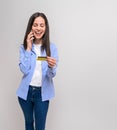 Smiling young businesswoman holding credit card and talking over smart phone on white background Royalty Free Stock Photo