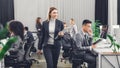 Smiling young businesswoman holding folder with papers and looking at coworkers while walking Royalty Free Stock Photo