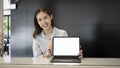 Smiling businesswoman holding and showing computer tablet with empty screen. Royalty Free Stock Photo