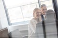 Smiling young businesswoman with male colleagues in meeting room Royalty Free Stock Photo