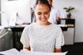 Smiling young businesswoman reading paperwork