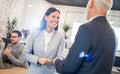 Smiling young businesswoman shaking hands with senior businessman in office Royalty Free Stock Photo