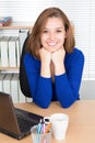 smiling young businesswoman sitting at computer desk in office Royalty Free Stock Photo