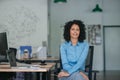 Smiling young businesswoman sitting at her desk in an office Royalty Free Stock Photo