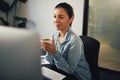 Smiling young businesswoman sitting in her office drinking tea Royalty Free Stock Photo