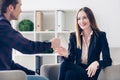 Smiling young businesswoman in suit giving interview to journalist Royalty Free Stock Photo