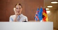 Smiling young businesswoman talking on telephone at reception Royalty Free Stock Photo