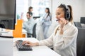 Smiling young businesswoman working with colleagues in a call center office, technical support operators. Royalty Free Stock Photo