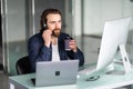 Smiling young call center man operator in headset working with laptop in office Royalty Free Stock Photo