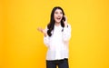 Smiling young casual Asian woman talking smart phone isolated over yellow background Royalty Free Stock Photo