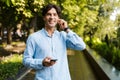 Smiling young casual man holding mobile phone Royalty Free Stock Photo