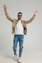 Smiling young casual man looking up and holding hands in the air Royalty Free Stock Photo