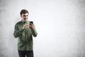 Smiling young casual man using smartphone, mock up Royalty Free Stock Photo