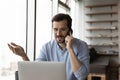 Young businessman work on laptop talk on smartphone Royalty Free Stock Photo