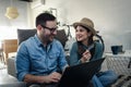 Smiling young Caucasian couple shopping online at home using a laptop with a credit card Royalty Free Stock Photo