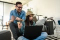 Smiling young Caucasian couple shopping online at home using a laptop with a credit card Royalty Free Stock Photo